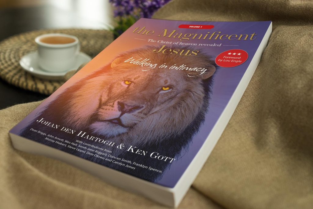 The Magnificent Jesus paperback on a table beside a cup of coffee